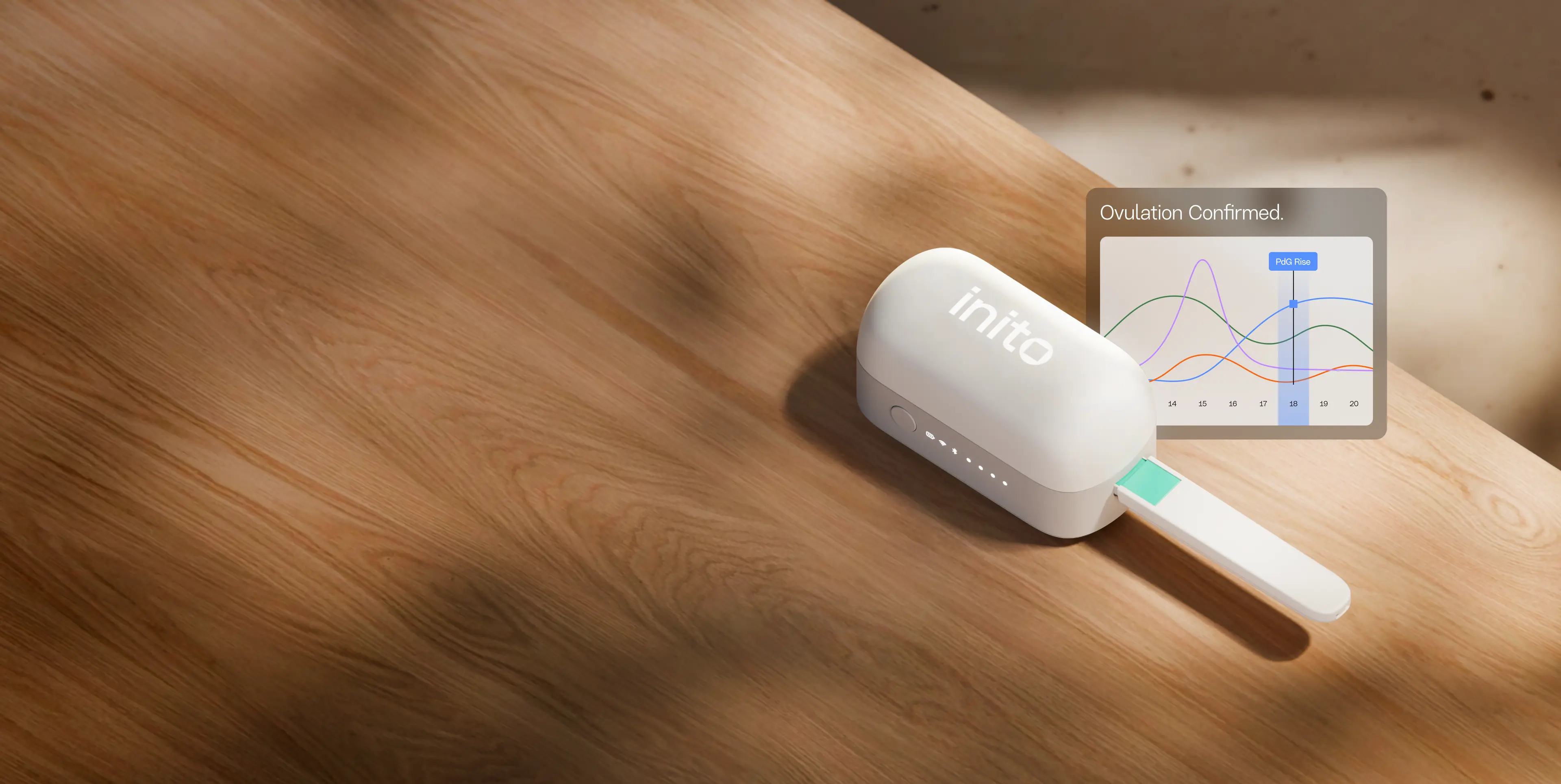 Inito fertility monitor device on a wooden desk